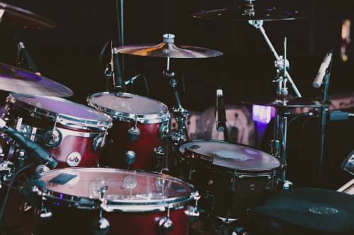 drum selective focus photography of red drum set musical instrument