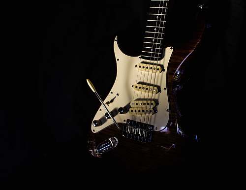 guitar selective focus photography of white and red electric guitar electric guitar