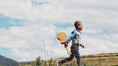 person boy running while holding ukelele human