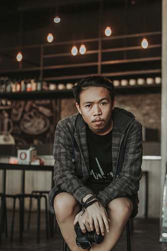 human man holding black Canon DSLR camera person