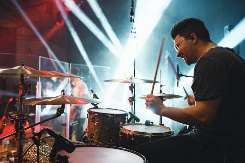 human man playing drums on stage person