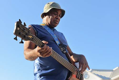 human man playing electric bass guitar person