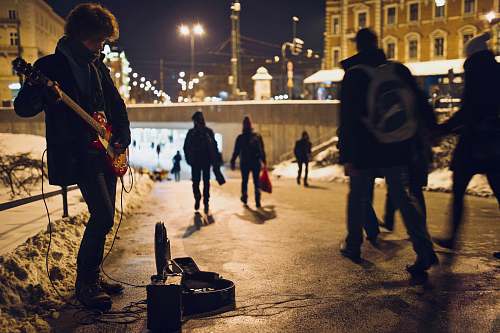 person man playing guitar on street during nighttime human