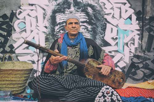 person man playing string instrument beside brown basket human