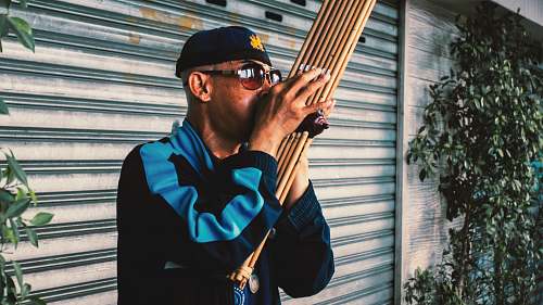 person man playing wood wind instrument outdoors human