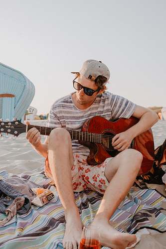 person man wearing gray tee shirt holding red guitar human