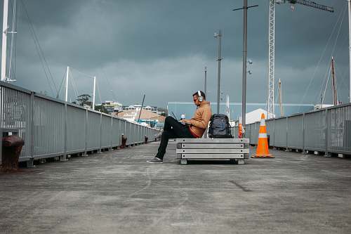 person person sitting on bench wearing headphones human