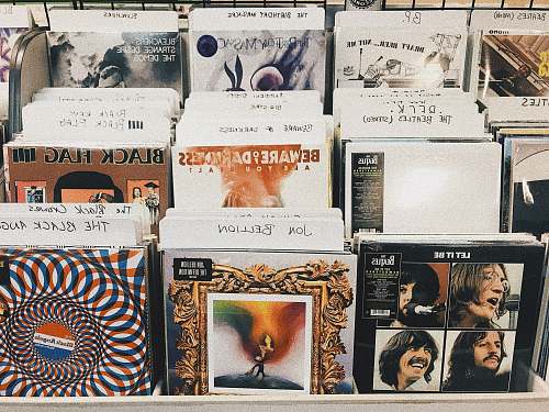 human pile of assorted-title vinyl album record sleeves person