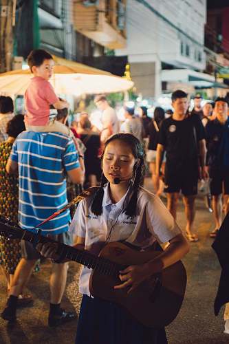person selective focus photo of girl playing guitar and singing human