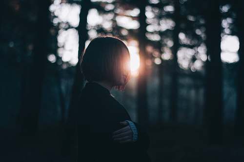 human woman in black cardigan near trees person