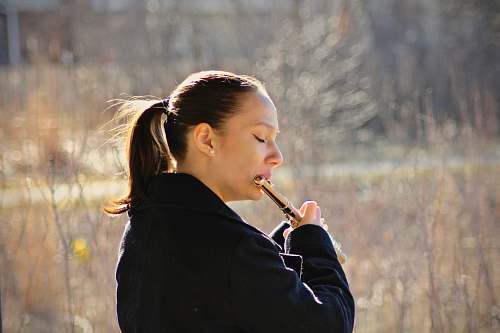 human woman playing flute on fields flute