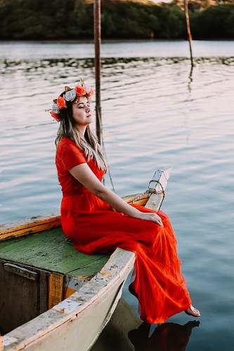 person woman sitting on boat in body of water while closing her eyes human
