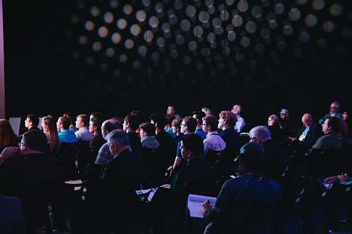 human crowd of people sitting on chairs inside room people