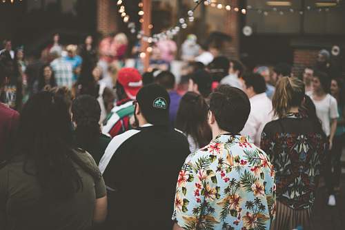 human group of people standing under string lights people