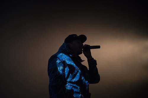 human man holding microphone low light photography music
