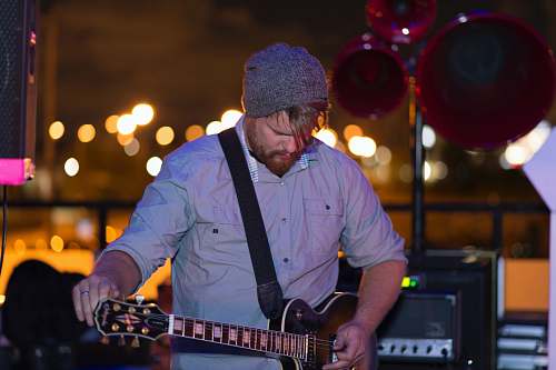 human man playing acoustic guitar people
