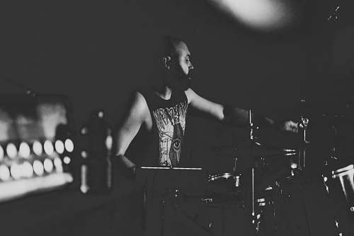human man playing drums black-and-white