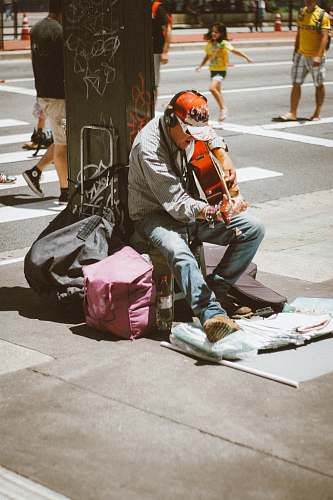 human man playing guitar in front of post people
