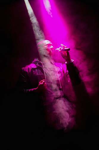 human man standing while holding microphone night life