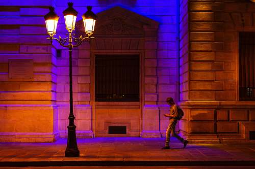 france man walking at sidewalk with turned on streetlight paris
