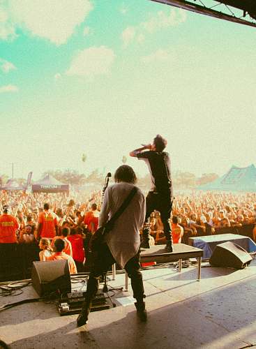 human men performing at the stage in front of people during day people
