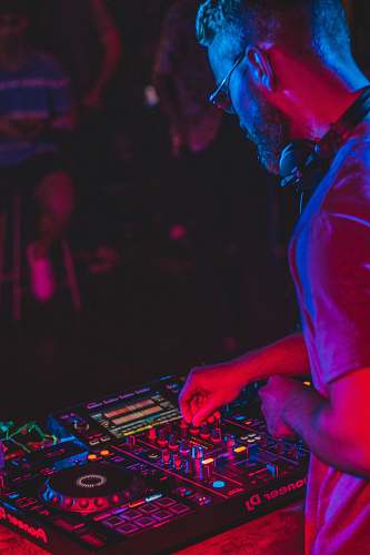 human person playing audio mixer in concert dj