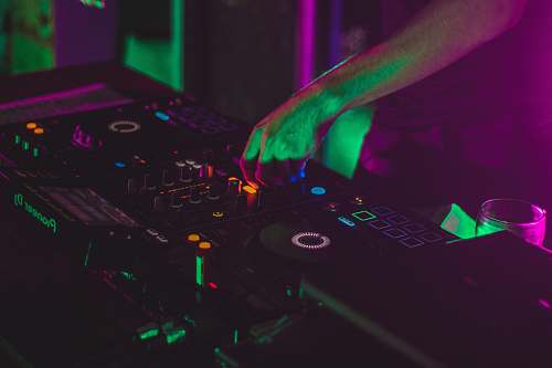 human person playing dj controller in a dark room dj