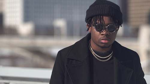 apparel selective focus photography of man wearing black knit hat and sunglasses clothing