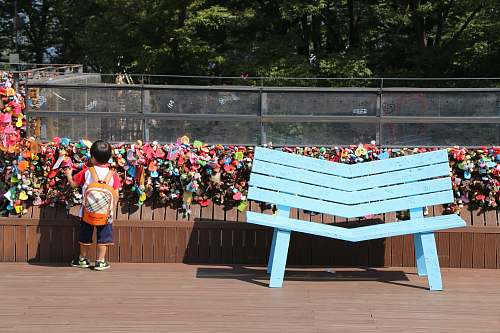 human toddler standing near blue wooden bench bench