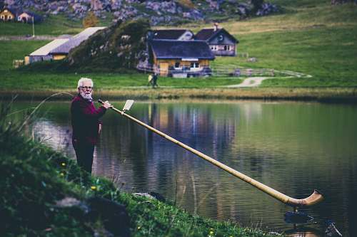 building woman holding elongated wind instrument at the lake house