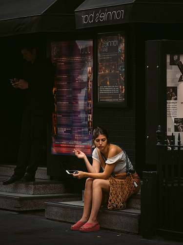human woman holding smartphone sitting on Ronnie's Bar store people