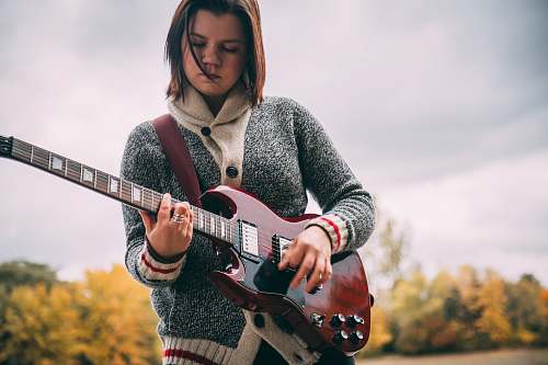 human woman playing guitar during daytime people