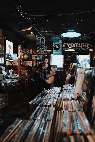 human woman sings while playing guitar people
