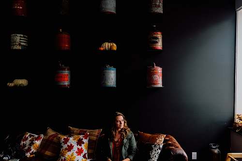 people woman sitting on couch with throw pillows inside the room human