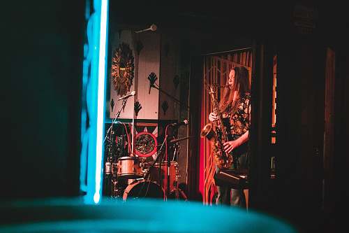 singapore woman playing saxophone on stage near wall clock sax