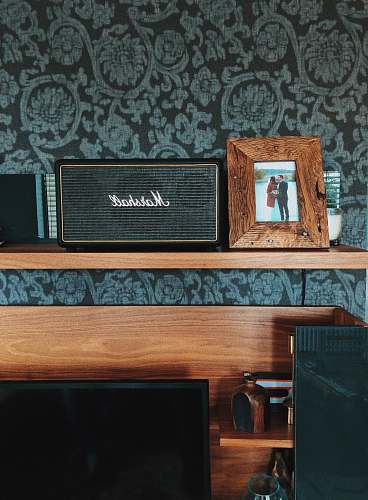 hardwood black Marshall speaker beside photo frame plywood