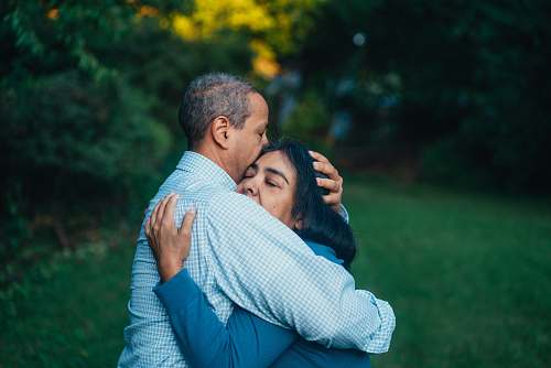  man hugging woman near trees 
