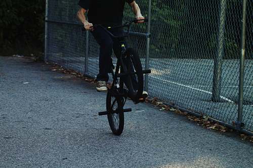 bike person riding BMX bike near chain link fence bmx