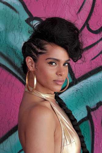 person Alicia Keys standing near wall with graffiti art woman