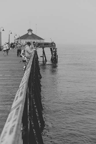 person Black and white photograph of people fishing on a pier at Imperial Beach black-and-white