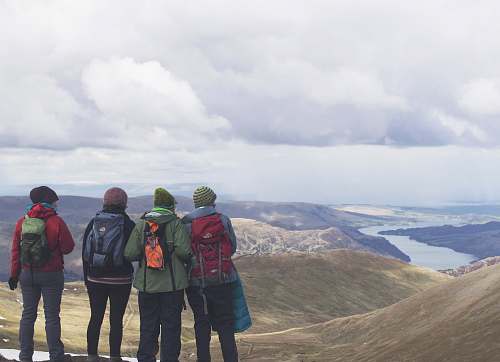 person four person standing while looking on mountain view with body of water at daytime view