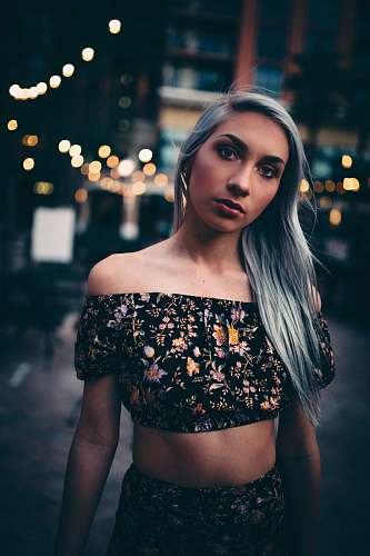 human gray haired woman wearing black-and-multicolored floral 2-piece crop dress person