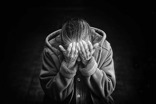 human grayscale photography of person covering face black-and-white