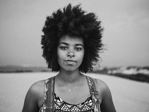 black-and-white grayscale photography of woman standing on wide field portrait