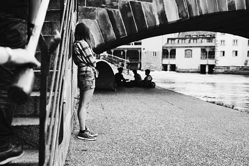 human grayscale photography woman leaning on concrete stairs outdoors black-and-white