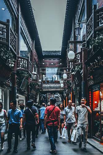 person group of people between buildings human