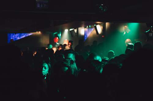 person group of people inside dimly lit room with green light human
