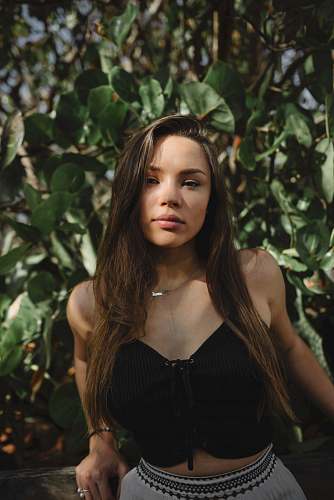 person lowlight photography of woman in black crop top near plants girl