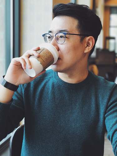 person man holding Starbucks disposable cup human