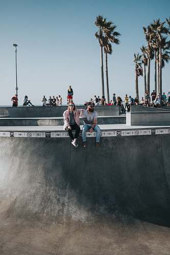 person man in blue denim pants seating beside woman human